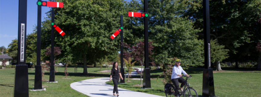 Image of a cyclist and pedestrian walking through Norris-Ward Park